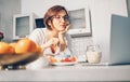 Woman prepare breakfast and watch laptop on kitchen Royalty Free Stock Photo