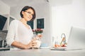 Woman prepare breakfast and watch a news in laptop Royalty Free Stock Photo