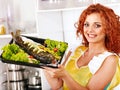 Woman prepare fish in oven.