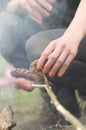 Woman prepare tasty sausages on campfire. Roasting sausages.