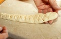 A woman prepares a burger as braids of dough