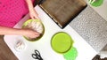 A woman prepares a dough for rye bread. Kneads the dough in a container, periodically dusting it with flour. Filmed from above