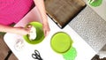 A woman prepares a dough for rye bread. Kneads the dough in a container, periodically dusting it with flour. Filmed from above