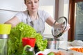 Woman prepares a healthy meal in modern kitchen.