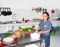 Woman prepares in the kitchen a duck balinese style