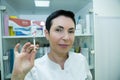 Dr. cometologist. A woman prepares a syringe with medication to correct wrinkles