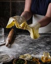 A woman prepares a thin yellow dough for spaghetti.