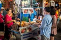 Woman prepares traditional Thai style grilled meat stick on the