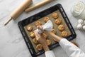 Woman preparing biscuits at marble table, top view. Cooking delicious food