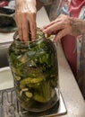 Woman preparing cucumbers for marinating