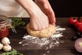 Woman preparing dough for pizza. Hands kneading dough on the wooden table