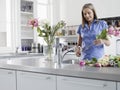 Woman Preparing Flowers For Vase At Kitchen Sink Royalty Free Stock Photo
