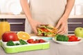 Woman preparing food for her child at table in kitchen, closeup. Royalty Free Stock Photo