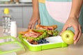 Woman preparing food for her child at table in kitchen. Healthy school lunch Royalty Free Stock Photo