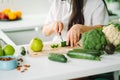 Woman preparing food in her kitchen. Female chopping fresh green vegetables on cutting board in light kitchen. Healthy Royalty Free Stock Photo