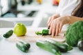Woman preparing food in her kitchen. Female chopping fresh green vegetables on cutting board in light kitchen. Healthy Royalty Free Stock Photo