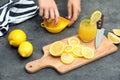 Woman preparing fresh lemon juice on grey table Royalty Free Stock Photo