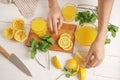 Woman preparing fresh lemon juice on light table Royalty Free Stock Photo