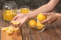 Woman preparing fresh lemon juice at wooden table Royalty Free Stock Photo