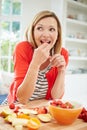 Woman Preparing Fruit Salad In Kitchen