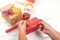 Woman preparing gifts for autumn holidays, birthday or thanksgiving day. Autumn composition. Handmade wrapped gift boxes, autumn l