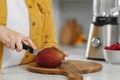 Woman preparing mango for tasty smoothie at white marble table in kitchen, closeup Royalty Free Stock Photo