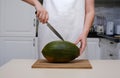 a cook in the kitchen cuts a ripe melon, close-up of hands Royalty Free Stock Photo