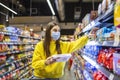 Woman preparing for pathogen virus pandemic spread quarantine.Choosing nonperishable food essentials.Budget buying at a supply Royalty Free Stock Photo