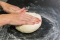 Woman preparing pizza dough on black granite table Royalty Free Stock Photo