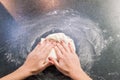 Woman preparing pizza dough on black granite table Royalty Free Stock Photo