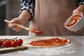 Woman preparing pizza at table in kitchen Royalty Free Stock Photo