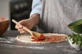 Woman preparing pizza at table in kitchen Royalty Free Stock Photo