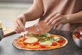 Woman preparing pizza at table in kitchen Royalty Free Stock Photo