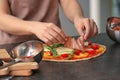 Woman preparing pizza at table in kitchen Royalty Free Stock Photo