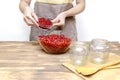 Woman preparing red currants in bowl for frozing,making jam in jars at home kitchen for winter.peeling summer fruits Royalty Free Stock Photo