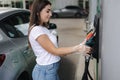 Woman is preparing for refueling at gas station. Female hand filling benzine gasoline fuel in car. Petrol prices concept Royalty Free Stock Photo