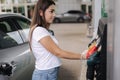 Woman is preparing for refueling at gas station. Female hand filling benzine gasoline fuel in car. Petrol prices concept Royalty Free Stock Photo