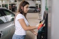 Woman is preparing for refueling at gas station. Female hand filling benzine gasoline fuel in car. Petrol prices concept Royalty Free Stock Photo