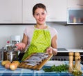 Woman preparing small fish indoors