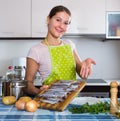 Woman preparing small fish indoors