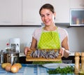 Woman preparing small fish indoors