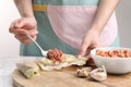 Woman preparing stuffed cabbage roll at white marble table, closeup Royalty Free Stock Photo