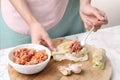 Woman preparing stuffed cabbage roll at white marble table, closeup Royalty Free Stock Photo