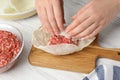 Woman preparing stuffed cabbage rolls at white wooden table, closeup Royalty Free Stock Photo