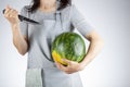 woman is preparing to stab a watermelon using a sharp kitchen knife.