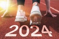 a woman preparing to start on an athletics track engraved with the year 2024 Royalty Free Stock Photo