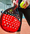 Woman preparing to throw a green ball with her paddle tennis racket in an indoor court Royalty Free Stock Photo