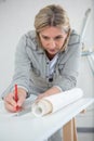 Woman preparing wallpaper to redecorate home