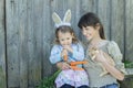 Woman and preschooler girl with cute Easter rabbit and carrots in arms Royalty Free Stock Photo