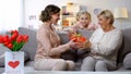 Woman presenting granny red gift box, girl congratulating her with mothers day